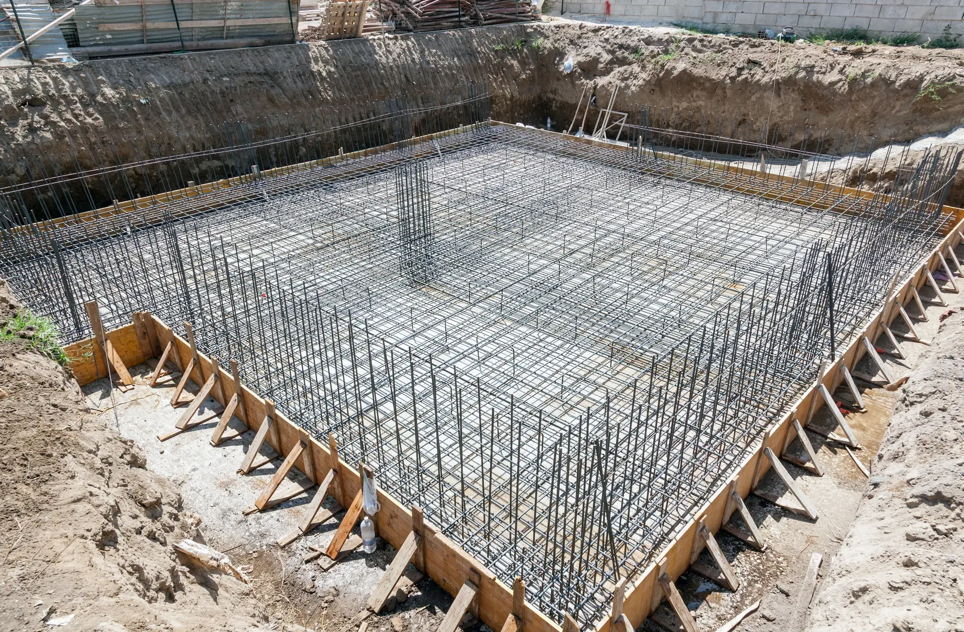 Reinforced concrete foundation with steel rebar framework prepared for a new house by Heart of Texas Construction LLC.