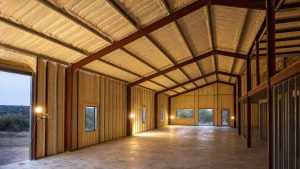 Interior of a metal building in Central Texas showing freshly applied cream-colored closed-cell spray foam insulation on the roof deck and wall panels